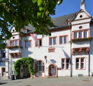 Kiedricher Rathaus, weisses Gebäude mit Sandsteinfensterrahmen und Fahne mit Kiedricher Wappen in rot und weiss