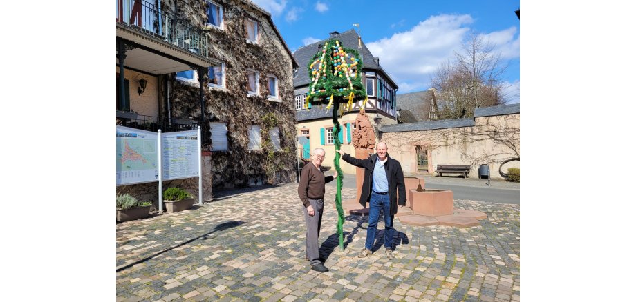 Osterglocke, bestehend aus bunten Ostereiern und grüner Girlande.