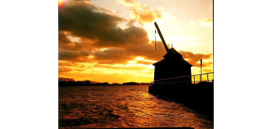 Ladekran in Abenddämmerung mit Wolken am Fluss Rhein.